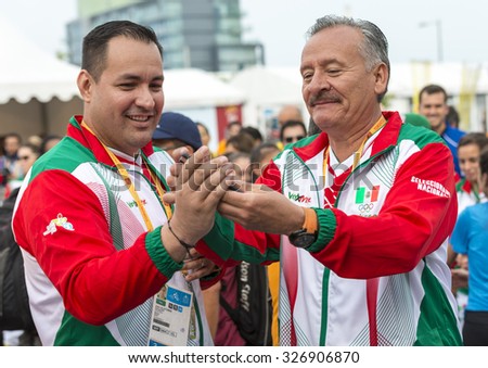 TORONTO,CANADA-JULY 8,2015: Mexican officials using mobile phone at the 2015 Pan Am Games. They were a major international multi-sport event