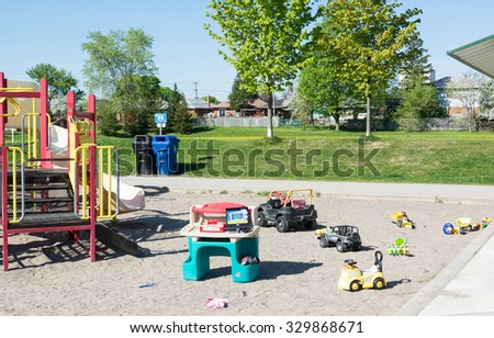 TORONTO,CANADA- JUNE 10,2015: Canada blessings. Children\'s play area at a park with toys all over the place in a sand-filled play area with slide and railed walk-way for children.