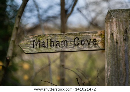 A wooden direction sign to Malham Cove.