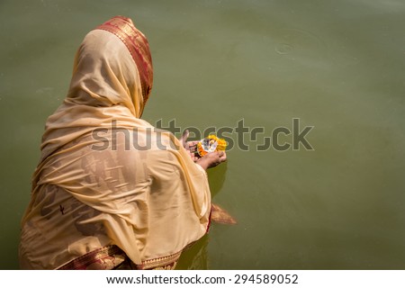 A woman making an Aarti offering. Aarti is a Hindu ritual of worship to Shiva, part of puja, in which light from wicks soaked in ghee is offered to one or more deities.