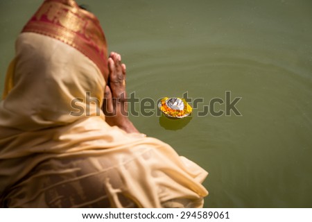 A woman making an Aarti offering. Aarti is a Hindu ritual of worship to Shiva, part of puja, in which light from wicks soaked in ghee is offered to one or more deities.