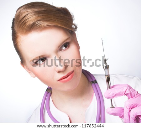 Nurse. Portrait of young woman in doctor\'s smock and with syringe.