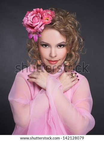 Young woman in pink vintage dress and with flowers in her hair.