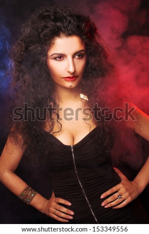 Young lady with long dark hair posing in smoke