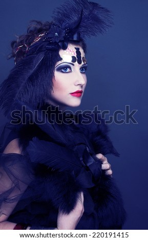 Halloween lady. Young woman in retro style and with feathers in her hair.