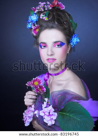 Romantic portrait of charming woman with artistic visage and flowers in her hair.