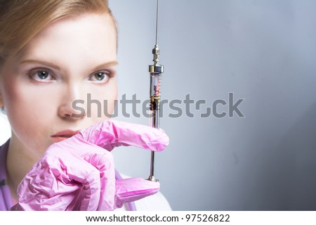 Nurse. Portrait of young woman in doctor\'s smock and with syringe.
