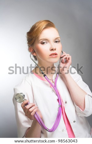 Portrait of young woman in doctor's smock and with stethoscope