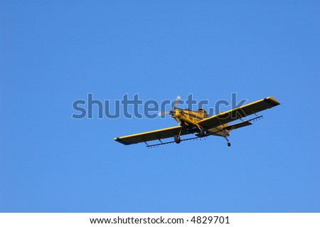 A crop dusting plane in flight.