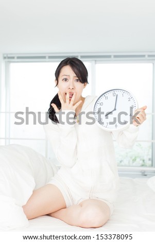 sleepy young woman with clock
