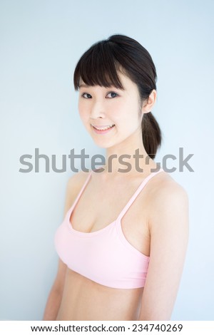 young fitness woman against pale blue background