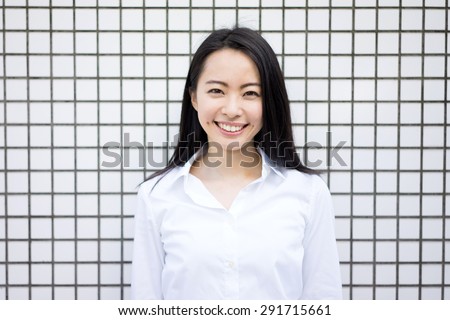young business woman against white tile wall