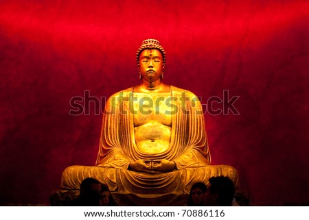 Statue representing Buddha in meditation on black background. Mass-produced plaster replica.