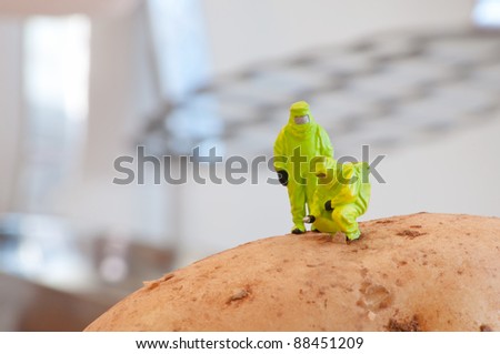 Group of Researchers in protective suit inspecting a potato. Genetically modified food concept