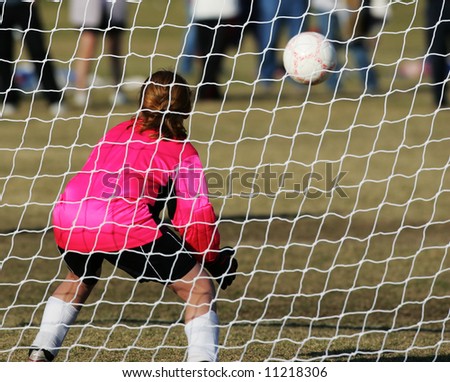 Female Soccer Goalie prepares to stop a goal