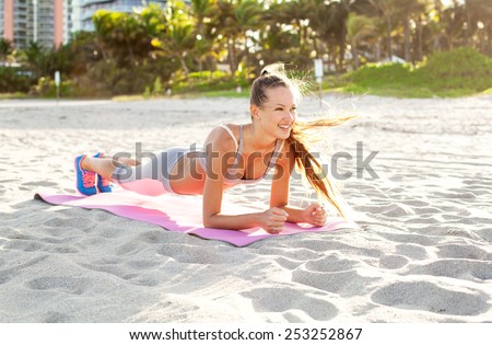 cheerful girl working out on the beach. fitness instructor making exercise.