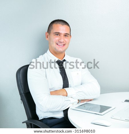 smiling business man working in the office using tablet computer