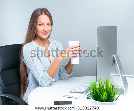 Portrait of smiling modern business woman in office working and drinking coffee