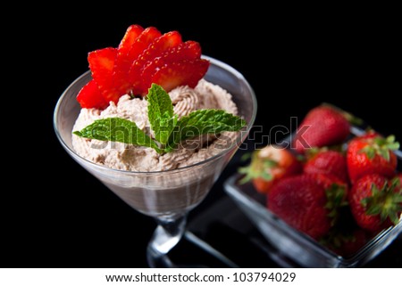 strawberries and chocolate mousse in a chilled martini glass with fresh mint garnish