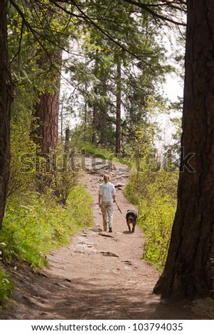 best friends walking on a path through the forest on a sunny day