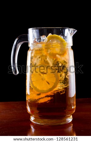 fresh made iced tea with lemon on a dark bar fading into black