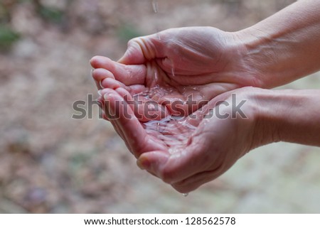 closeup of a female hand holding a small amount of water on her hand