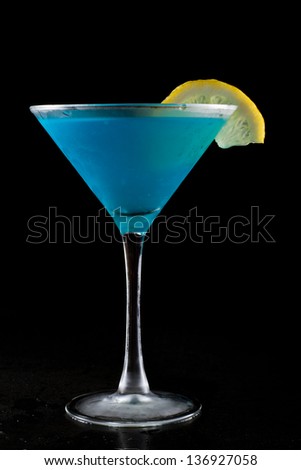 bright blue lemonade served in a martini isolated on a black background