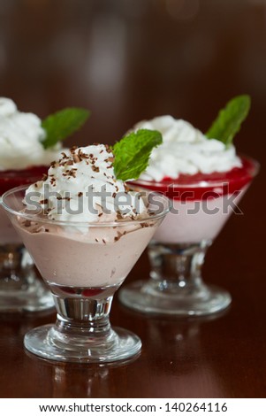 chocolate and strawberry mousse desserts served and garnished with whipped cream