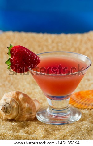 closeup of a strawberry martini served on the beach