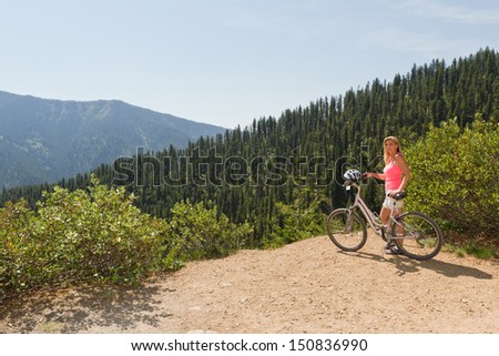 young woman on top of the mountain enjoying the view