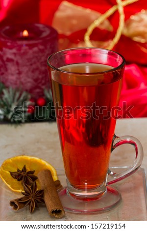 christmas morning tea served in a tall clear glass with spices and a red table cloth