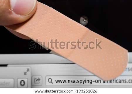 close up of a webcam being covered with a band aid for personal and home security