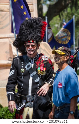 Bay Pines, Florida - May 26 : Bagpiper and navy veteran posing for a photo after the Memorial Day parade, May 26 2014 in Bay Pines VA cemetery in Florida