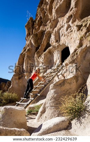 beautiful woman climbing into caves in Bandelier national Monument in New Mexico