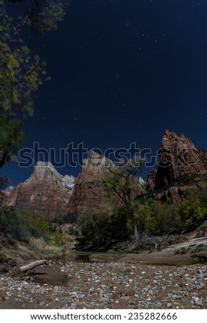 night time landscape at Zion national park with moon light on the mountains and bright stars on  the blue sky