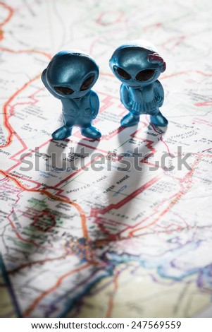 toy ETs standing on a Map of the United States, with the words Nevada test Site on the map
