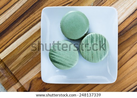 home made pistachio flavored french macaroons on a wooden table
