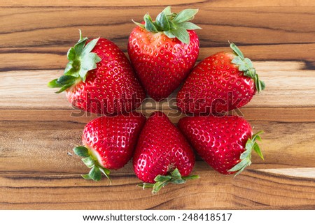 locally grown organic strawberries arranged in a circle on a wooden table