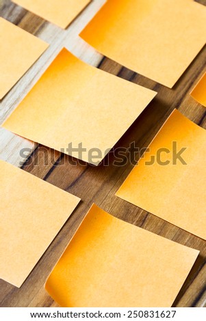 sticky orange notes on a wooden table for an office to do concept