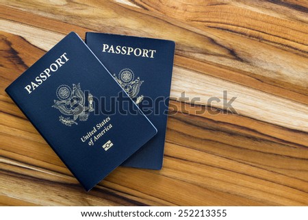 close up of two american passports on a wooden table for a travel concept