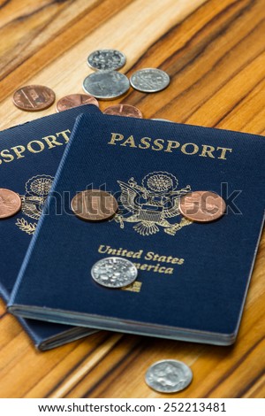 close up of two american passports and coins for a cheap travel concept