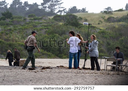 Carmel by the sea, California - May 06 : Park ranger checking on a group of students filming on the beach, May 06 2015 Carmel by the sea, California.