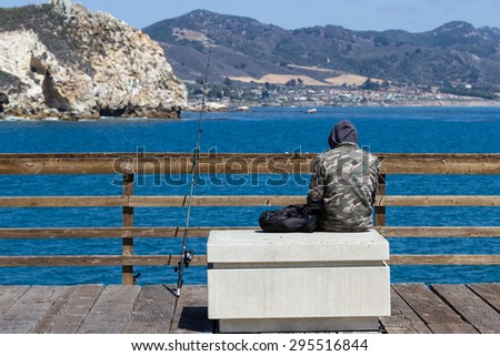 San Luis Obispo, California - May 03 : young man fishing of the pier on a cold morning, May 03 2015 San Luis Obispo, California.