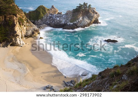 Waterfall in Julia Pfeifer Burns State Park at sunset with a soft golden color on the rocks