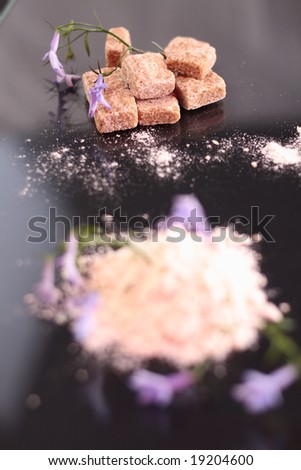 Brown sugar cubes and flour on black surface