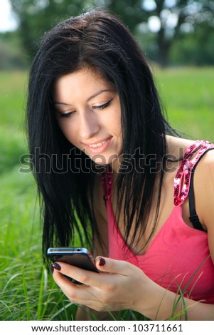 A young woman looking at phone and smiling