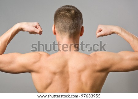 Back of sexy muscular man on a gray background