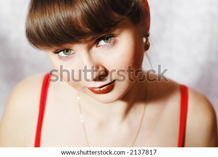 Young woman in red sleeveless, her eyes are green