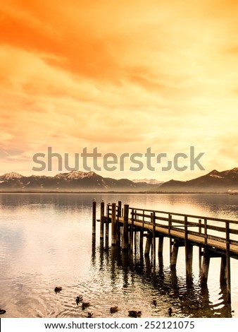 wooden jetty  on lake chiemsee with alps in background