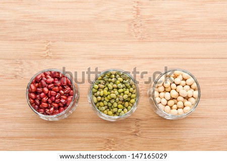 assorted beans, red bean, mung bean and soy bean in glass on wood background. with text space